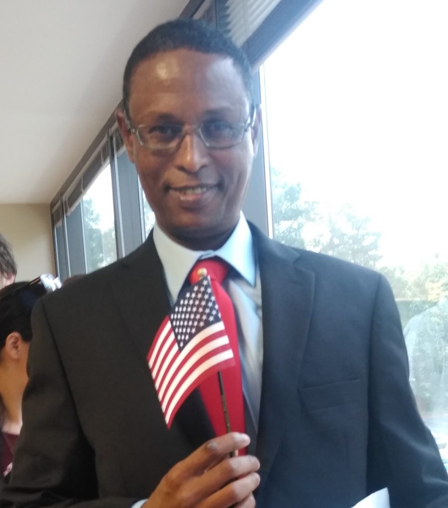 Abdirahman holding a small American Flag