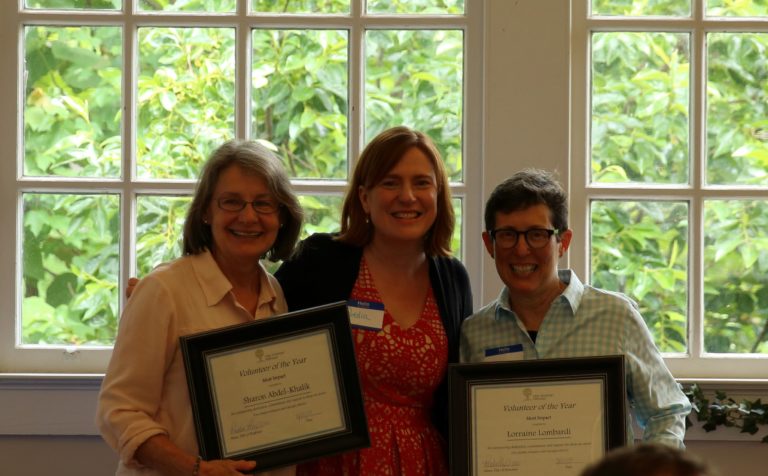 two people being presented with Volunteer of the Year award from New American Pathways