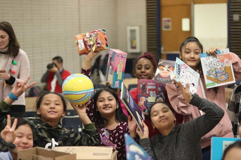 Group of children holding up donated items