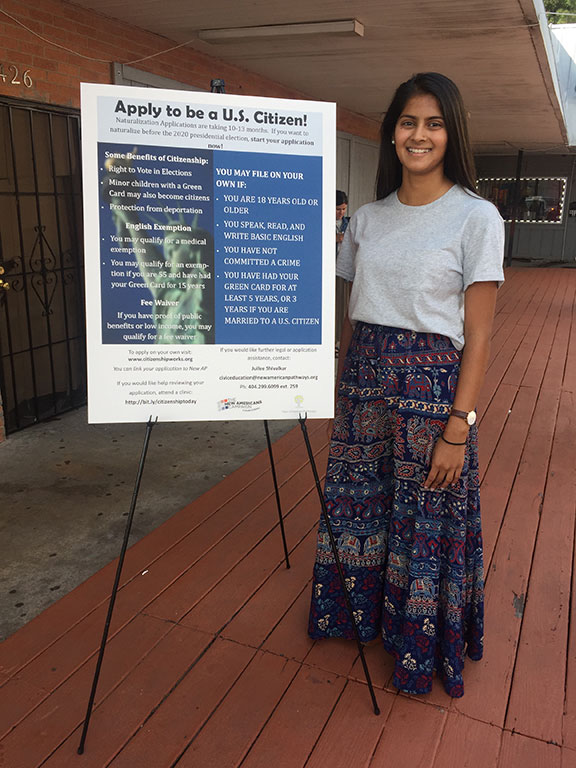 woman standing in front of an informational poster about applying to be a U.S. Citizen