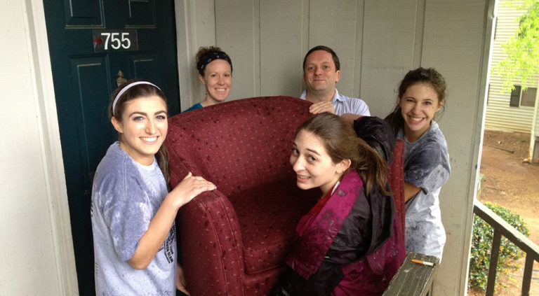 group of volunteers helping to move chair