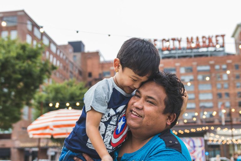 son being held by his dad in front of Ponce City Market