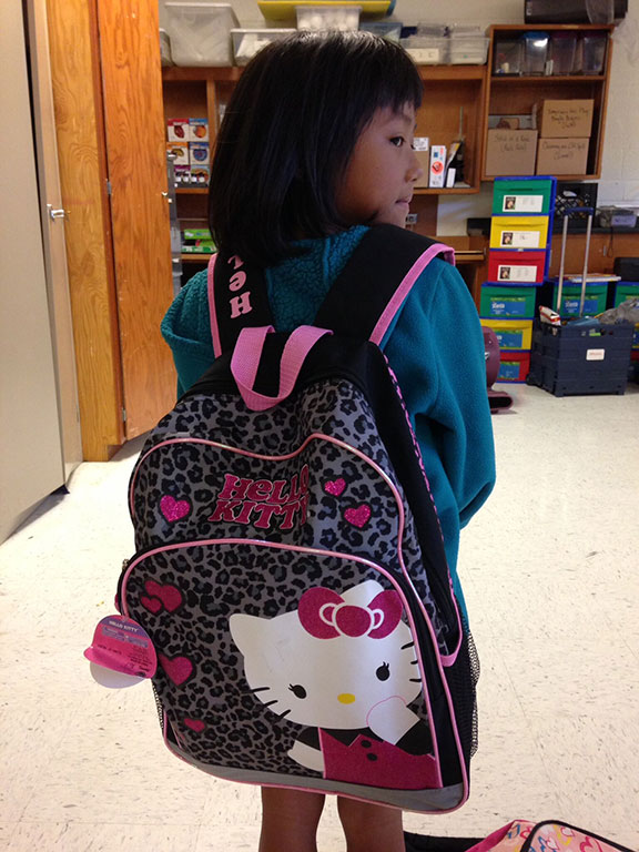 Young girl showing off her Hello Kitty backpack