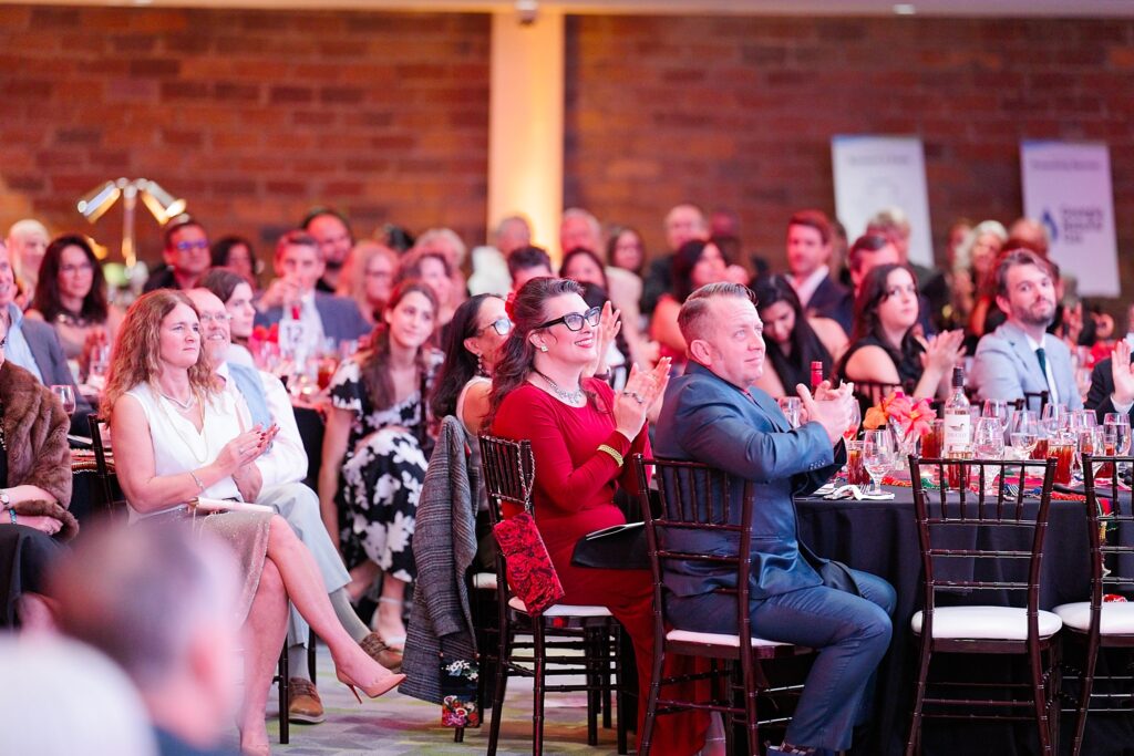 The 2025 New American Pathways Red, White, and Do gala crowd smiling up at the stage
